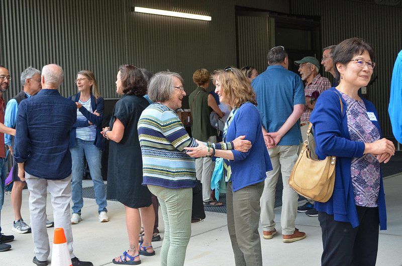 A large group of SPU employees chatting at the event.