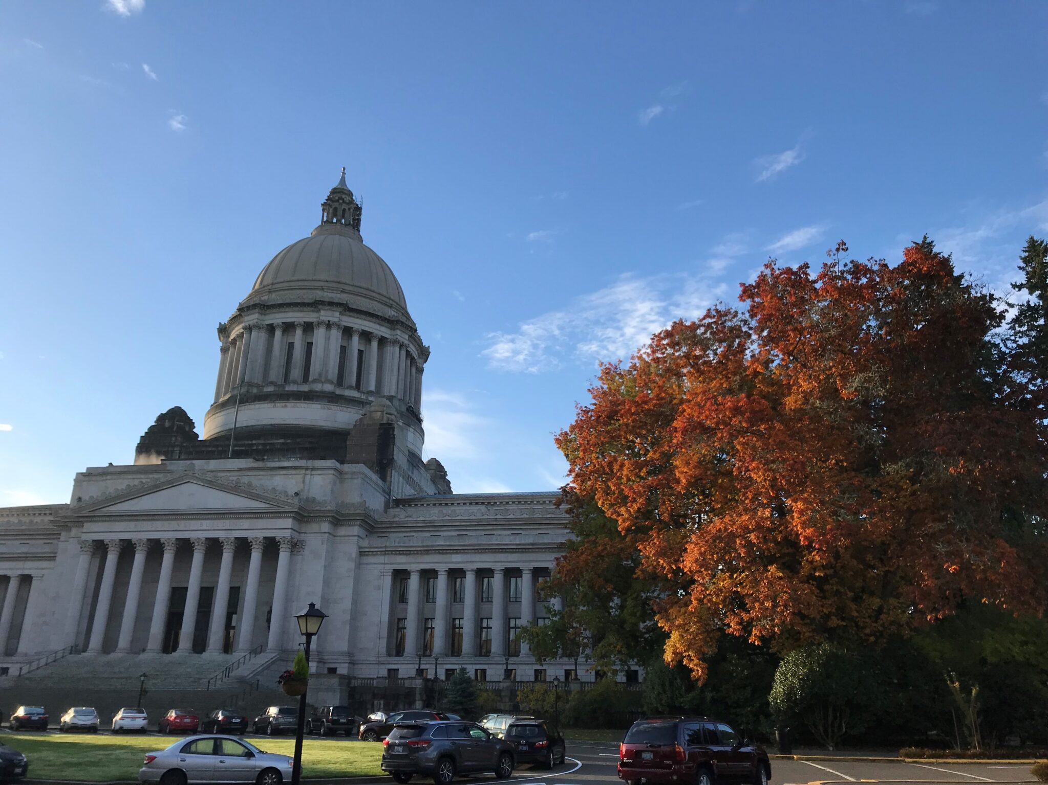 State capitol building with fall foliage alongside.