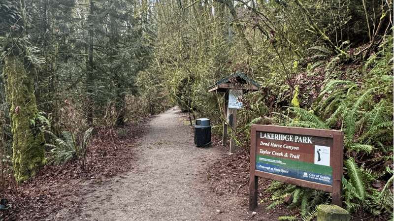 Trailhead at Lakeridge Park with signage and forest.