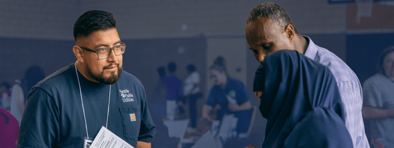 Customers talking to a SPU representative at a Connect & Assist event.