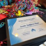 Confetti and an award certificate that reads, "Water Equity Network. Certificate of Achievement. The U.S. Water Alliance presents this certificate to: Seattle Taskforce Team. Remarkable Commitment to Centering Community Perspectives."