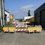 An alleyway with barricades and lead hazard warning signs.